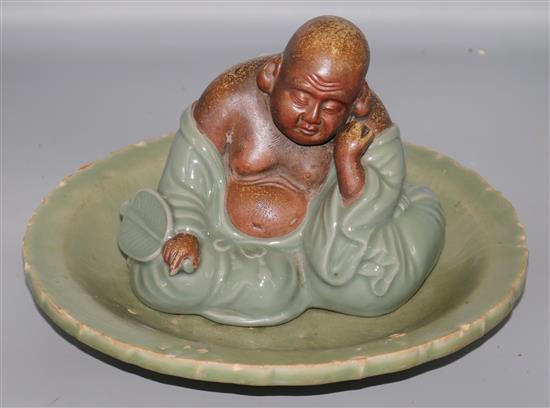 A Chinese Longquan celadon dish, 15th/16th Century and a celadon figures of Budai